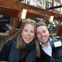 woman and man smile while sitting and drinking on boat tour